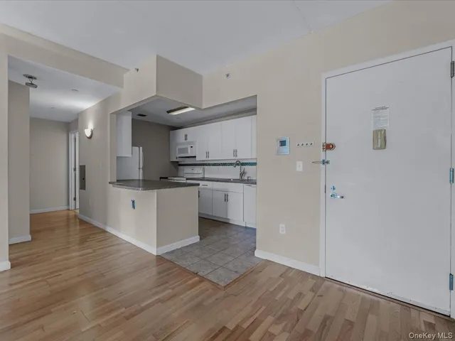 a large kitchen with a wooden floor and stainless steel appliances