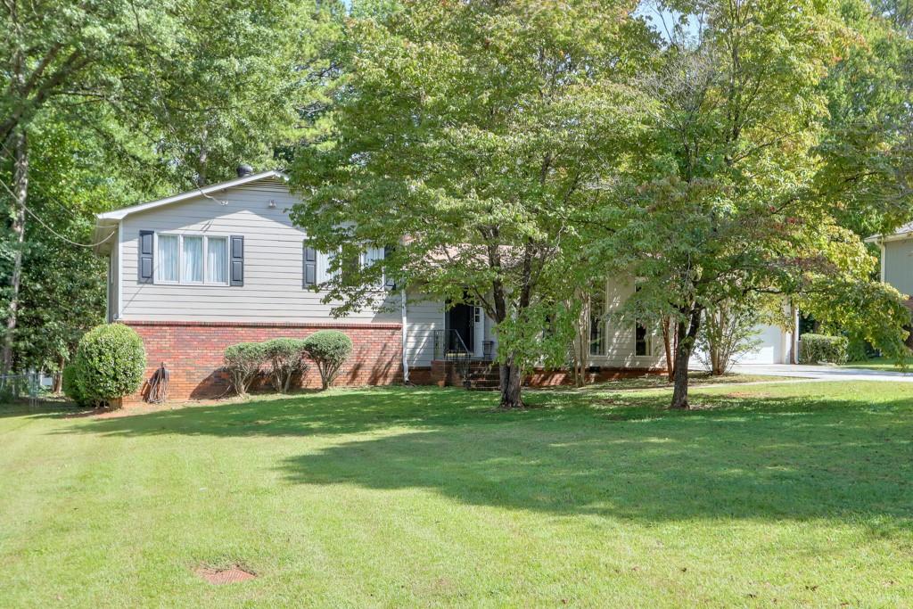 4380 Marsh Road Marietta, GA 30066 - Photo 1 of 1 a front view of a house with a yard and trees