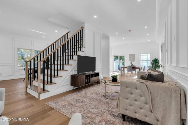 a living room with furniture a rug and a flat screen tv