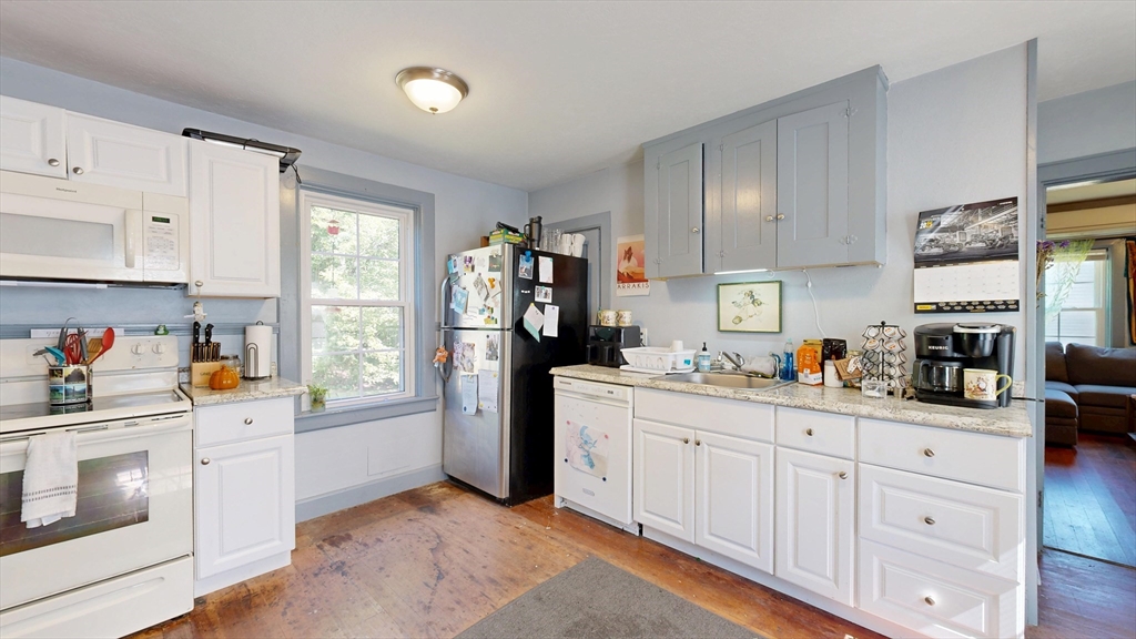 970 North Main Street Raynham, MA 02767 - Photo 12 of 42 a kitchen with white cabinets a stove a sink and a window