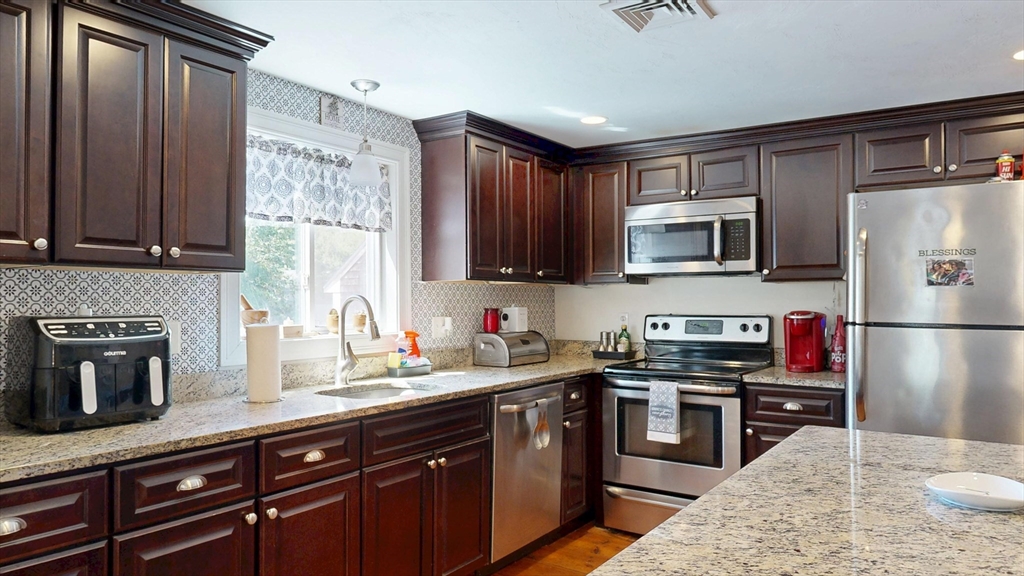 970 North Main Street Raynham, MA 02767 - Photo 19 of 42 a kitchen with stainless steel appliances granite countertop a stove a sink dishwasher a refrigerator and a microwave oven