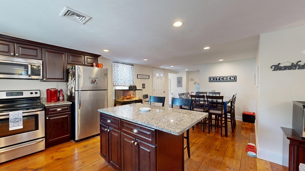 970 North Main Street Raynham, MA 02767 - Photo 20 of 42 a kitchen with stainless steel appliances granite countertop a refrigerator a stove a sink a dining table and chairs