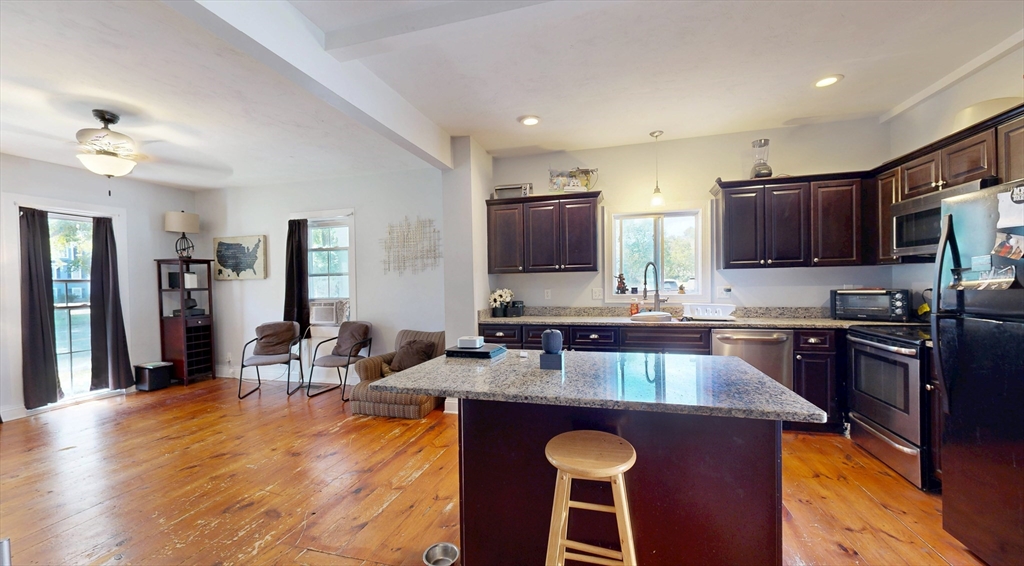 970 North Main Street Raynham, MA 02767 - Photo 2 of 42 a kitchen with stainless steel appliances granite countertop a stove top oven a sink dishwasher a dining table and chairs with wooden floor