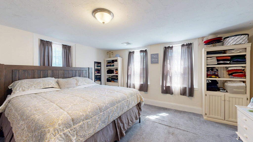 970 North Main Street Raynham, MA 02767 - Photo 24 of 42 a bedroom with a large bed and a book shelf