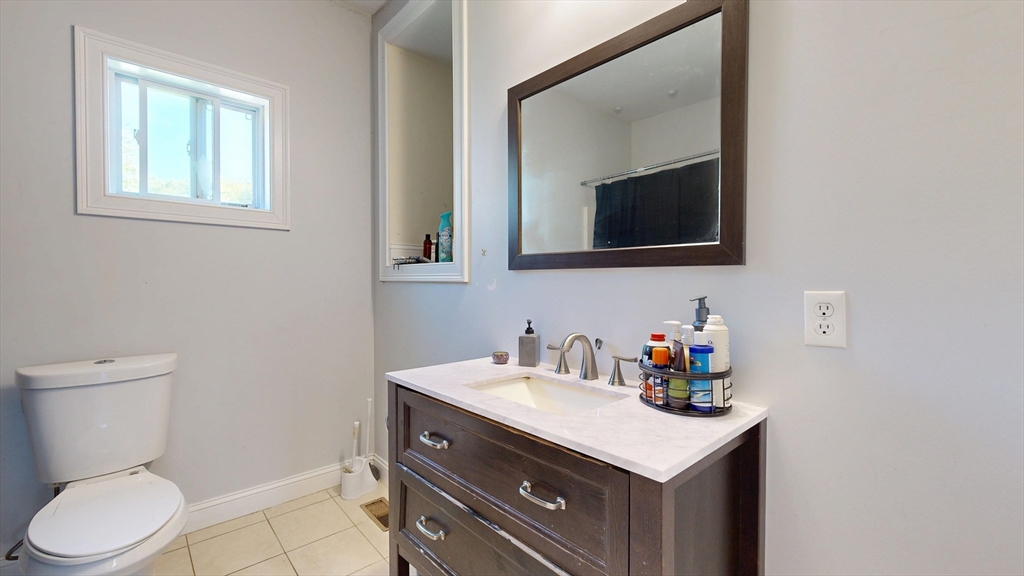 970 North Main Street Raynham, MA 02767 - Photo 9 of 42 a bathroom with a toilet sink vanity and mirror