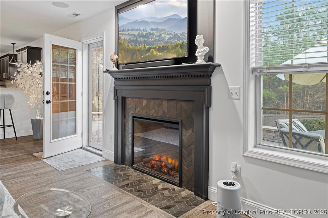 681 New Castle Lane Spring Lake, NC 28390 - Photo 19 of 50 a living room with a fireplace and a floor to ceiling window