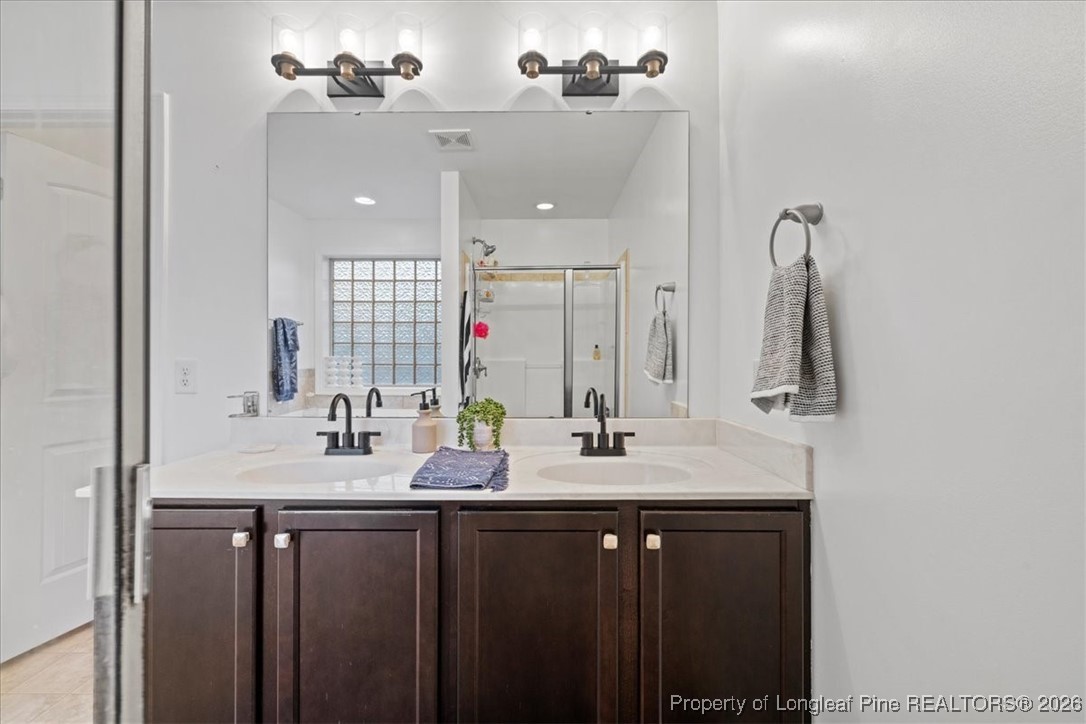 681 New Castle Lane Spring Lake, NC 28390 - Photo 32 of 50 a bathroom with double sink and a mirror