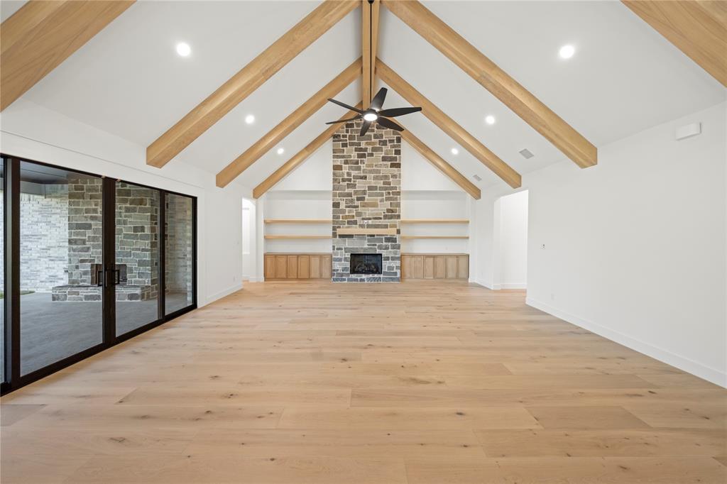 108 Bel Grand Road Haslet, TX 76052 - Photo 16 of 36 Spacious room featuring vaulted ceilings with exposed wood beams, a stone fireplace, wood-finish flooring, and recessed lighting