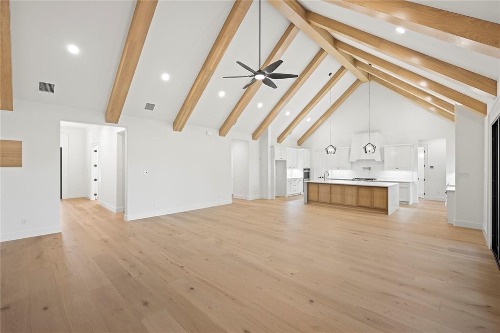 108 Bel Grand Road Haslet, TX 76052 - Photo 18 of 36 Expansive open-concept living space featuring a vaulted ceiling with exposed wood beams, recessed lighting, and a contemporary ceiling fan