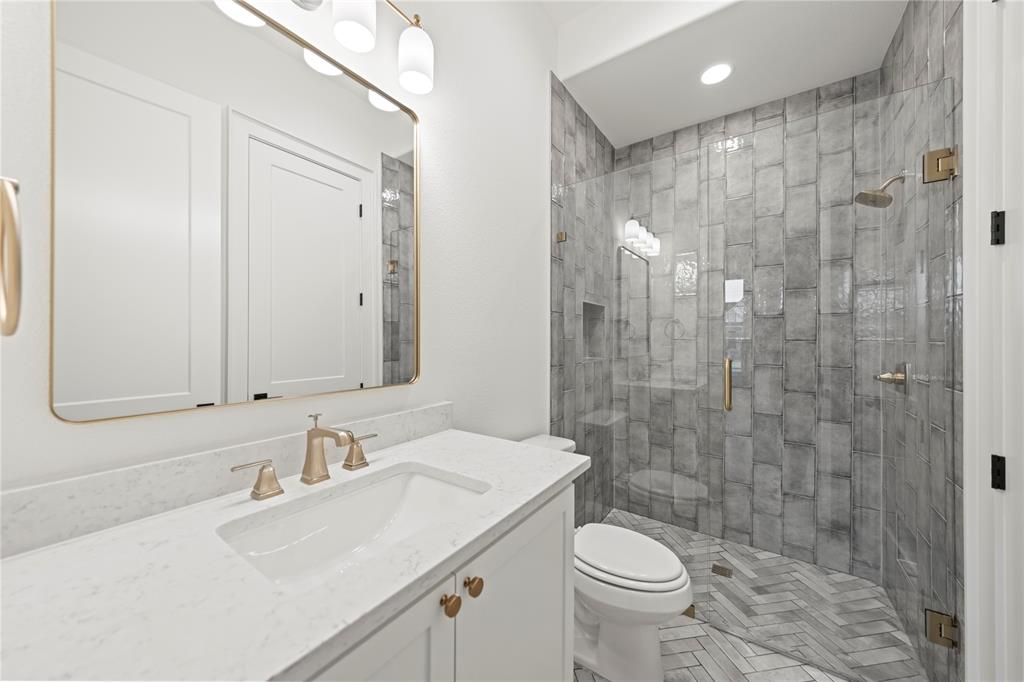 108 Bel Grand Road Haslet, TX 76052 - Photo 26 of 36 Bathroom featuring a white vanity with a quartz countertop, gold-finish hardware, and a framed mirror