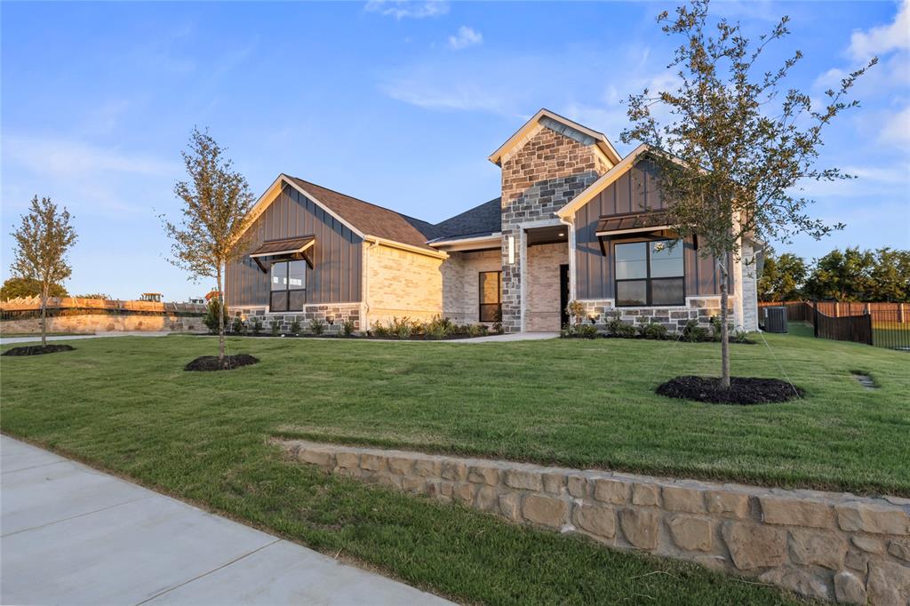 108 Bel Grand Road Haslet, TX 76052 - Photo 3 of 36 Contemporary exterior featuring a stone and board-and-batten facade, complemented by a gabled roofline