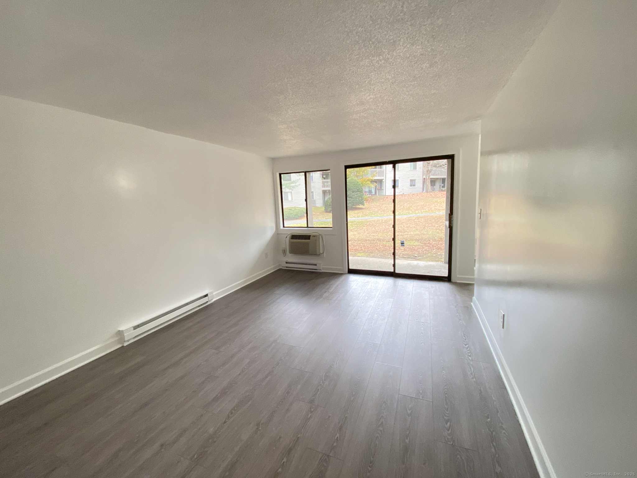 7 Padanaram Road, Unit I181 Danbury, CT 06811 - Photo 2 of 20 an empty room with wooden floor and windows
