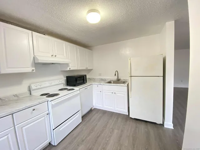 a kitchen with a white cabinets and white appliances