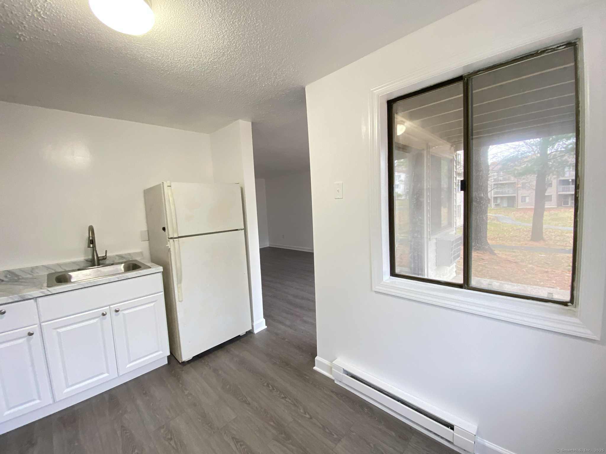 7 Padanaram Road, Unit I181 Danbury, CT 06811 - Photo 6 of 20 a room with a refrigerator and a sink