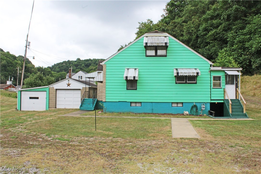 63 Mc Coll Road Colliers, WV 26035 - Photo 1 of 17 View of side of property featuring a garage and a yard