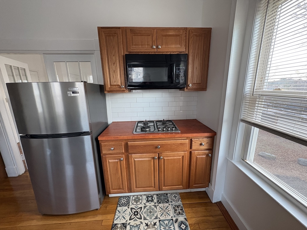 21 Juniper Street, Unit 2 Boston, MA 02119 - Photo 3 of 12 a kitchen with a refrigerator and a stove