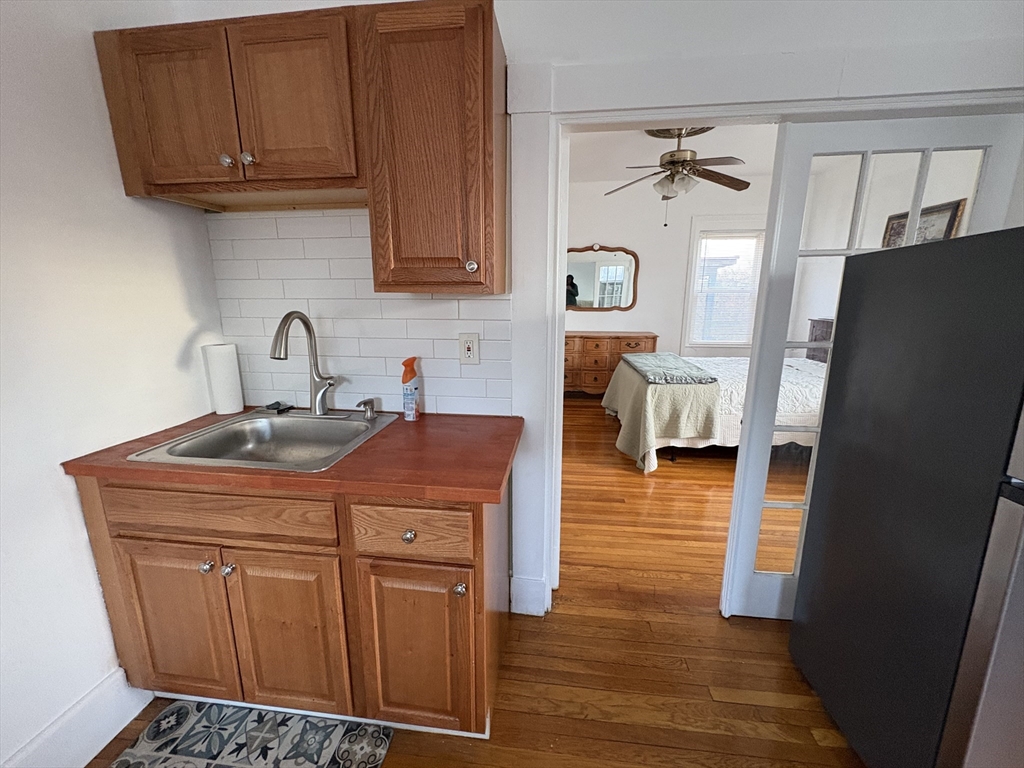 21 Juniper Street, Unit 2 Boston, MA 02119 - Photo 5 of 12 a kitchen with stainless steel appliances a refrigerator and cabinets
