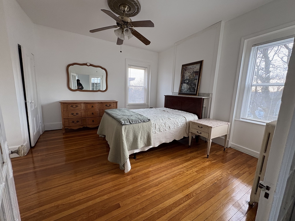 21 Juniper Street, Unit 2 Boston, MA 02119 - Photo 6 of 12 a bedroom with a bed and wooden floor