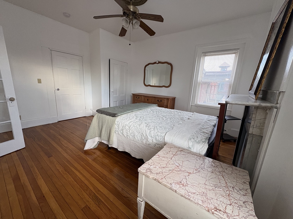 21 Juniper Street, Unit 2 Boston, MA 02119 - Photo 7 of 12 a bedroom with a bed and wooden floor