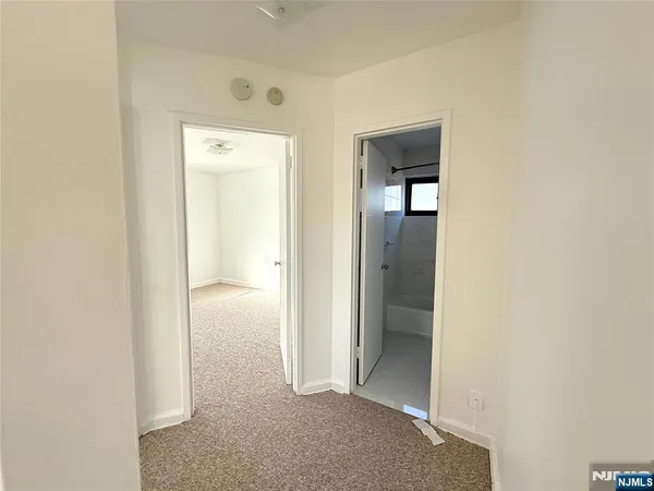 a view of a hallway with closet and wooden floor