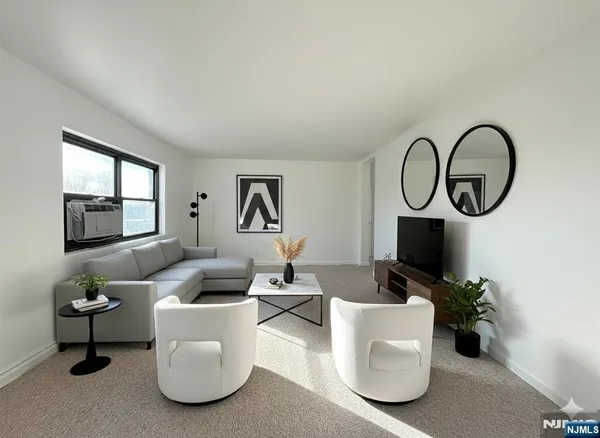 a living room with furniture a flat screen tv and a window