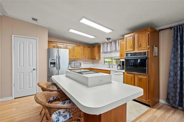 a kitchen with a stove a sink dishwasher and a refrigerator