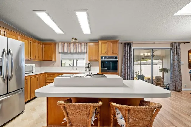 a kitchen with a table chairs refrigerator and window