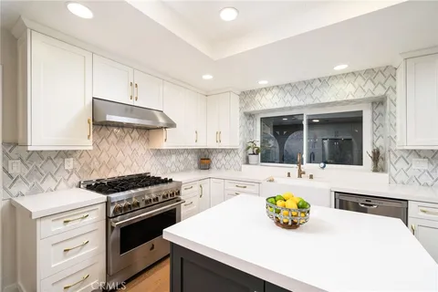 a kitchen with a sink a stove and cabinets
