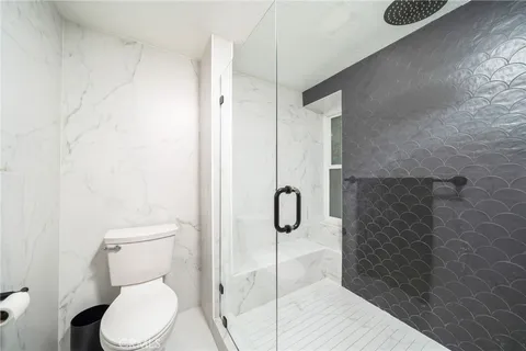 a bathroom with a toilet and a shower