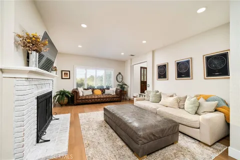 a living room with furniture fireplace and mirror