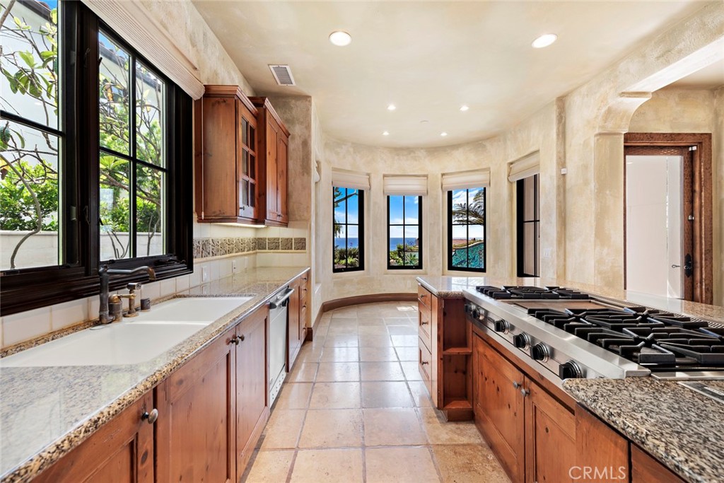 40 Timor Sea Newport Coast, CA 92657 - Photo 12 of 50 a kitchen with stainless steel appliances granite countertop a sink stove and refrigerator