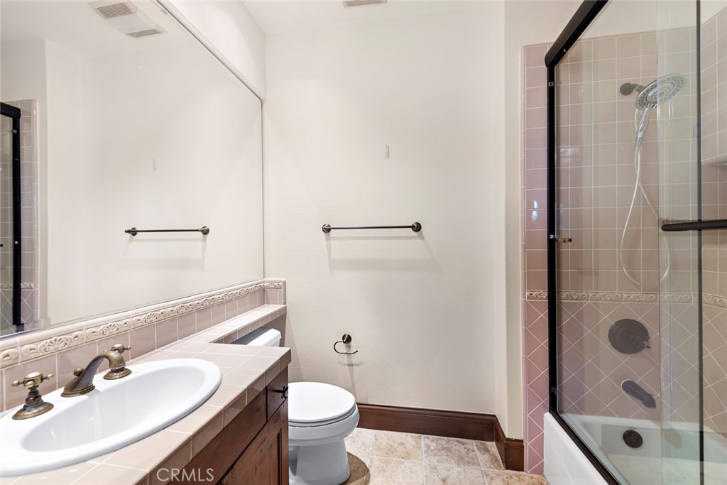 40 Timor Sea Newport Coast, CA 92657 - Photo 39 of 50 a bathroom with a sink a toilet a glass door a shower and a mirror