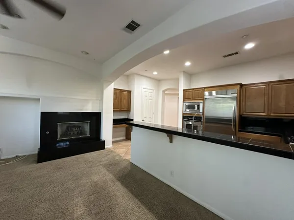 a open kitchen with a refrigerator and a fireplace