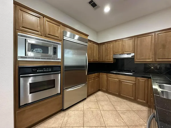 a kitchen with granite countertop a stove and a microwave