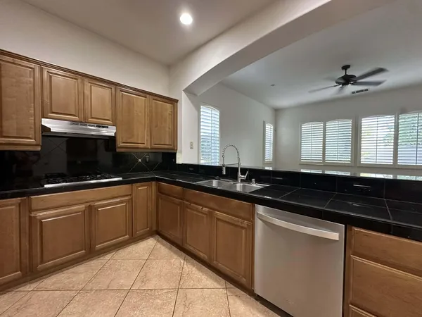 a kitchen with granite countertop a sink stainless steel appliances and cabinets
