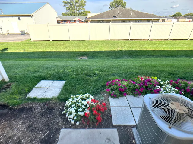 a view of a garden with flowers and a table