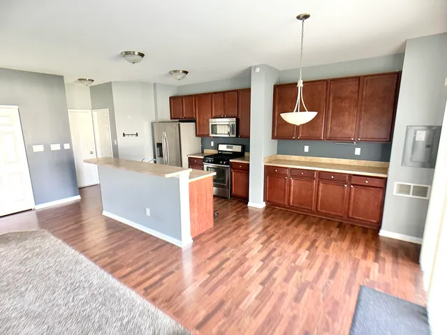 a kitchen with stainless steel appliances granite countertop a sink a stove a refrigerator and cabinets