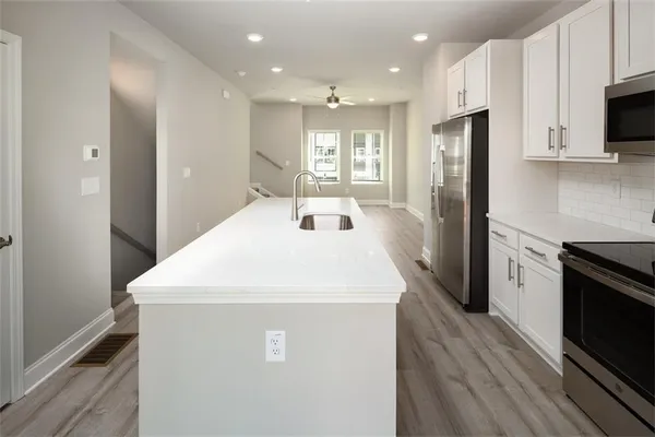 a kitchen with kitchen island a sink stainless steel appliances and cabinets