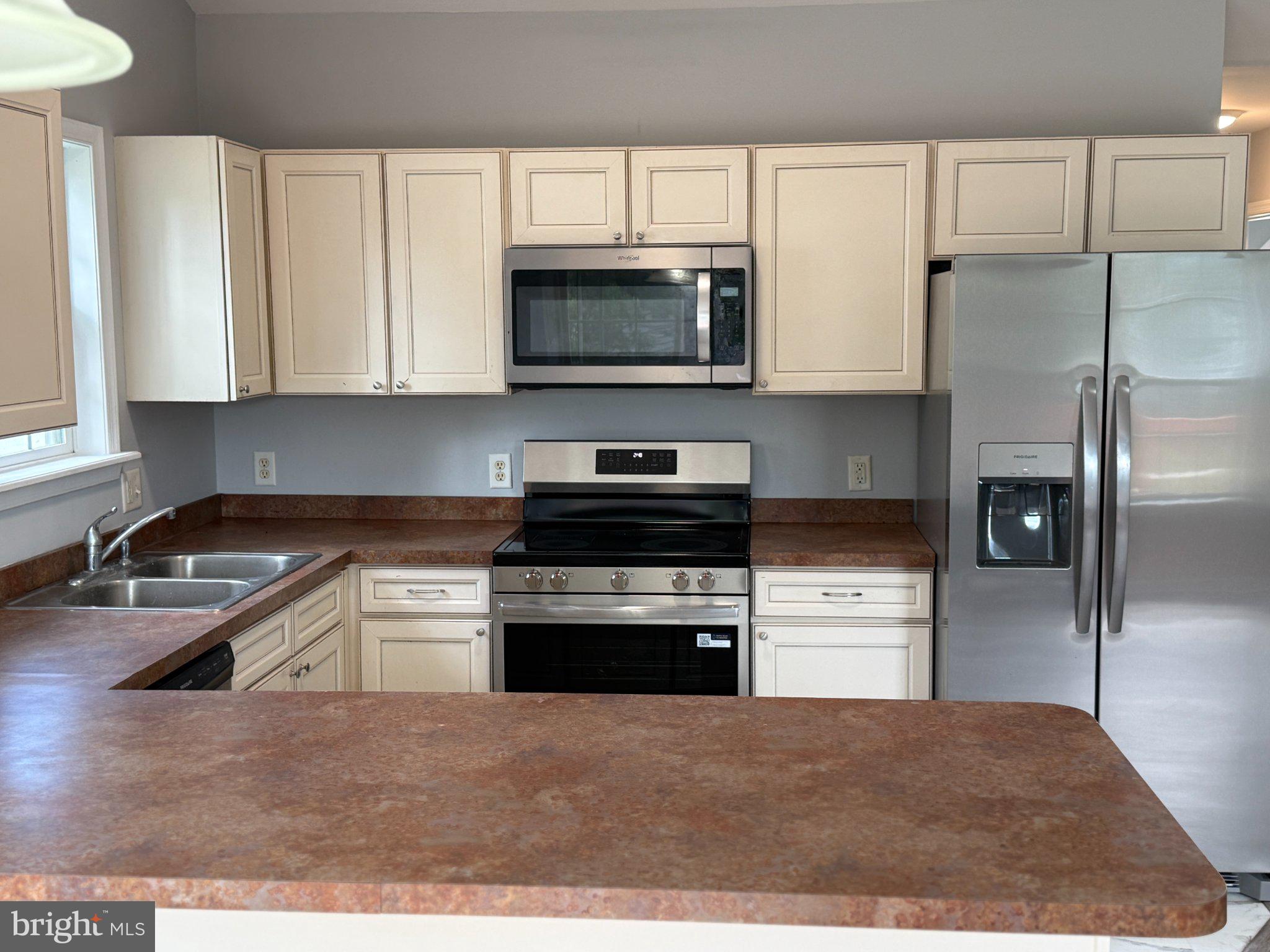 30952 Sandy Ridge Drive Lewes, DE 19958 - Photo 4 of 17 a kitchen with kitchen island a sink stainless steel appliances and cabinets