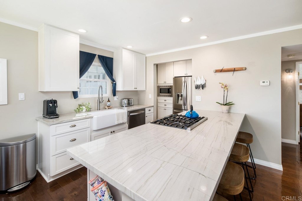 220 Coneflower Street Encinitas, CA 92024 - Photo 3 of 25 a kitchen that has a lot of cabinets a sink and a stove in it