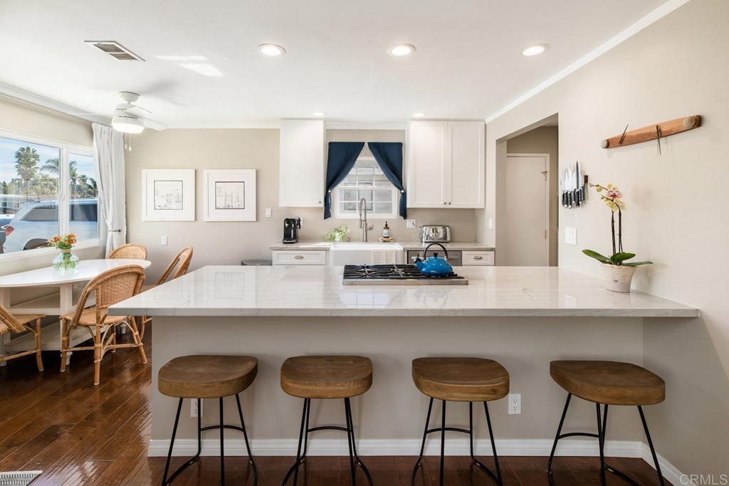 220 Coneflower Street Encinitas, CA 92024 - Photo 4 of 25 a kitchen with a dining table chairs sink and wooden floor