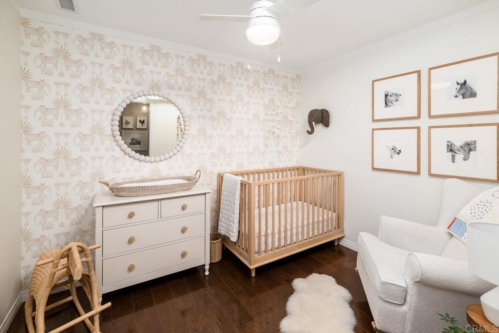 220 Coneflower Street Encinitas, CA 92024 - Photo 10 of 25 a bedroom with a baby bed a couch and dresser