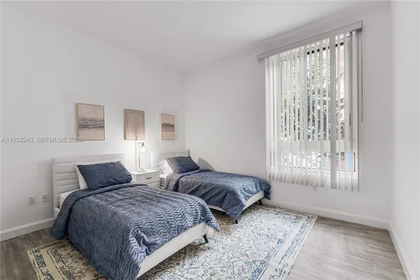 a bedroom with two beds and a window