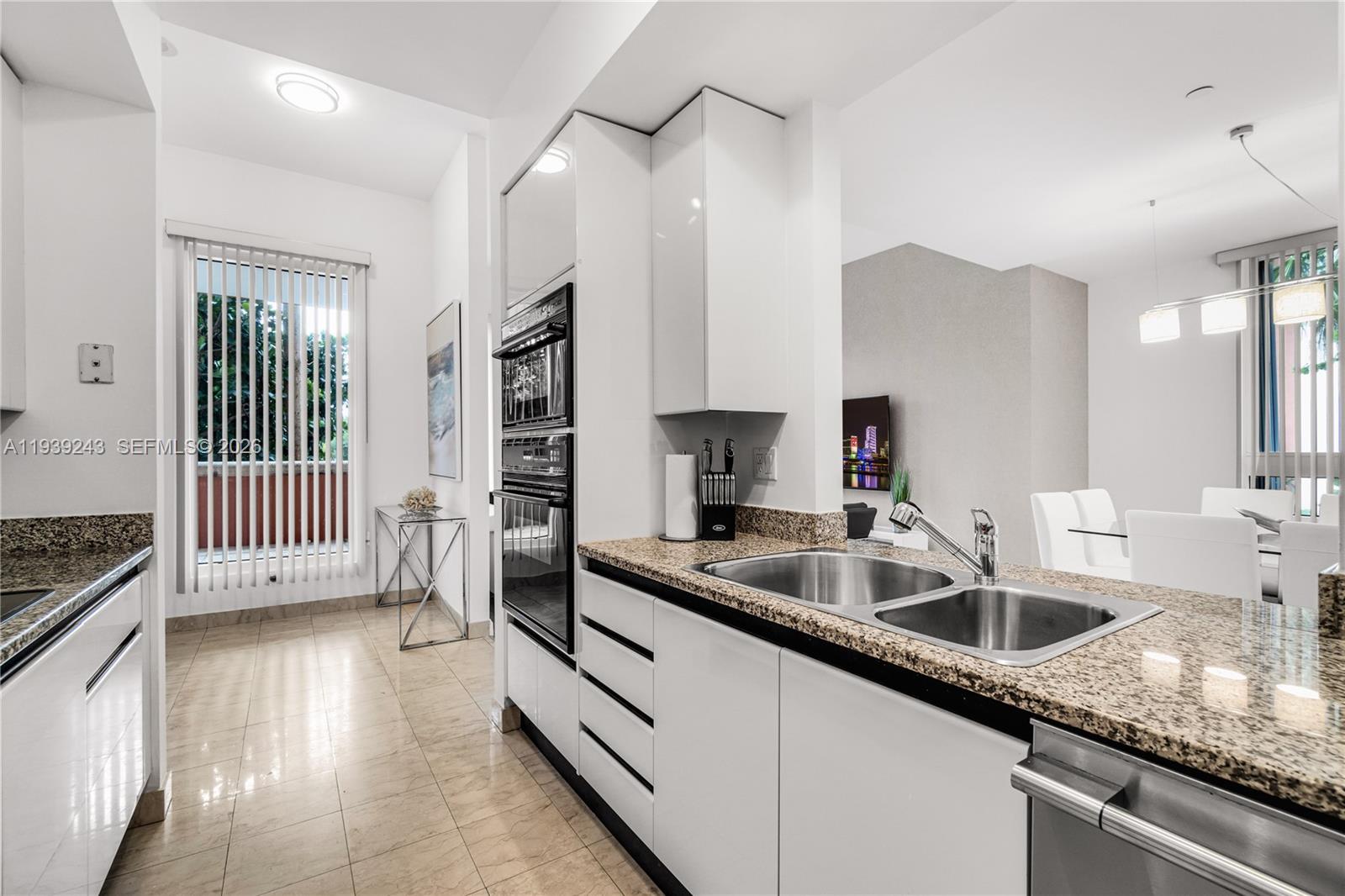 785 Crandon Boulevard, Unit 106 Key Biscayne, FL 33149 - Photo 7 of 22 a kitchen with granite countertop a sink and a stove top oven
