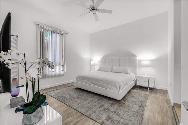 a bedroom with a large bed and a flat tv screen on a dresser