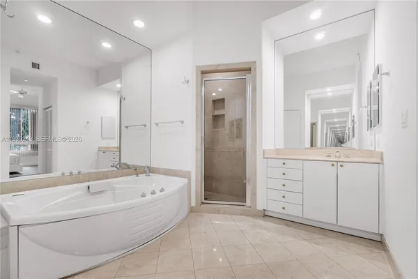 a spacious bathroom with a tub sink shower and mirror