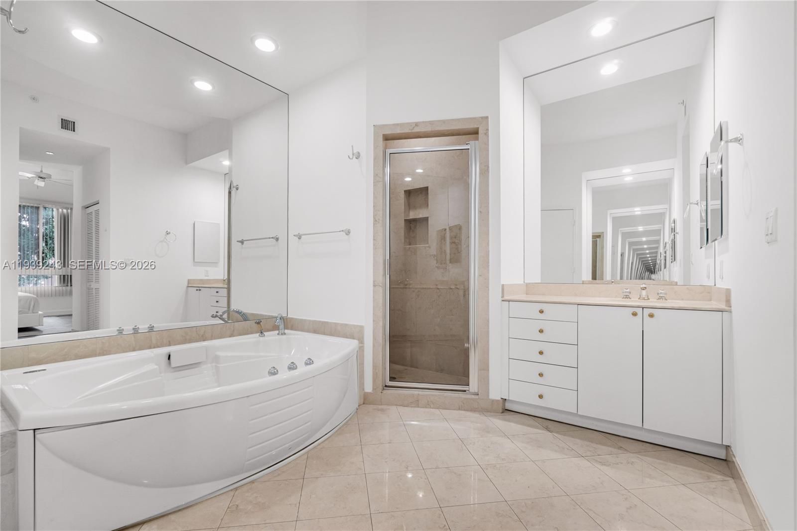 785 Crandon Boulevard, Unit 106 Key Biscayne, FL 33149 - Photo 10 of 22 a spacious bathroom with a tub sink shower and mirror