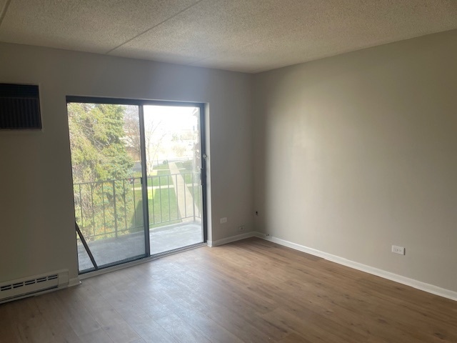 950 North Rohlwing Road, Unit 101A Addison, IL 60101 - Photo 2 of 7 an empty room with wooden floor and windows