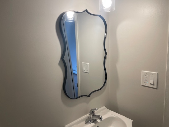950 North Rohlwing Road, Unit 101A Addison, IL 60101 - Photo 5 of 7 a bathroom with a mirror and a sink