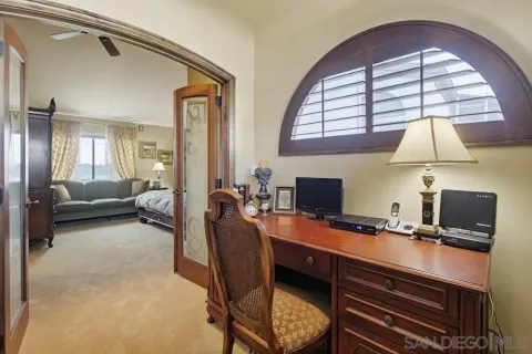 a view of a workspace with furniture and a window